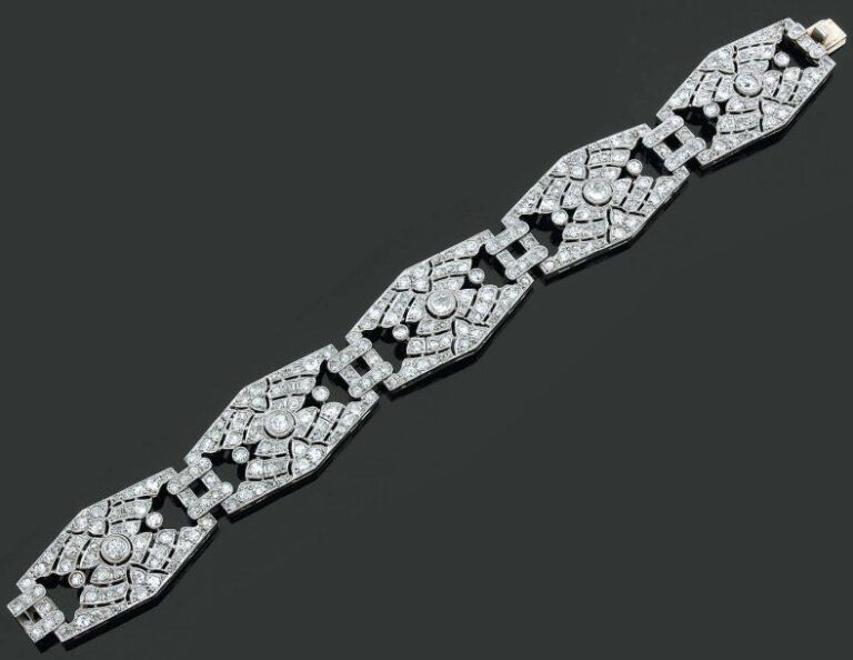 BRACELET manchette en platine et or gris ajouré et articulé serti de diamants de taille ancienne, à motifs géométrique