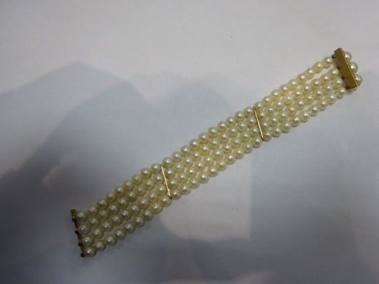 BRACELET manchette formé de quatre rangs de perles de culture à barrettes et fermoir à glissière en or jaune 18K (750°/00