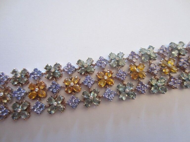 BRACELET MANCHETTE souple en or rose 14 carats (585 millièmes) ajouré composé de trois lignes de fleurettes serties de saphirs multicolores ponctués de diamant