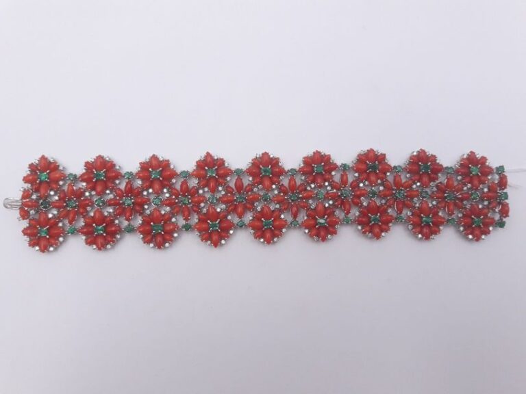 BRACELET manchette souple «fleurs» en or gris (750 millièmes) articulé, serti de corail cabochon de forme navette, d'émeraudes et diamants taille brillan