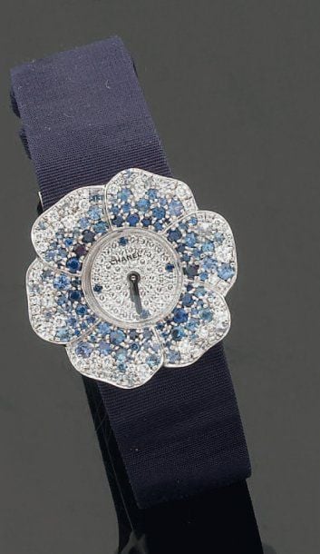 BRACELET MONTRE « Camélia » en or gris entièrement serti de pavages de diamants et saphir