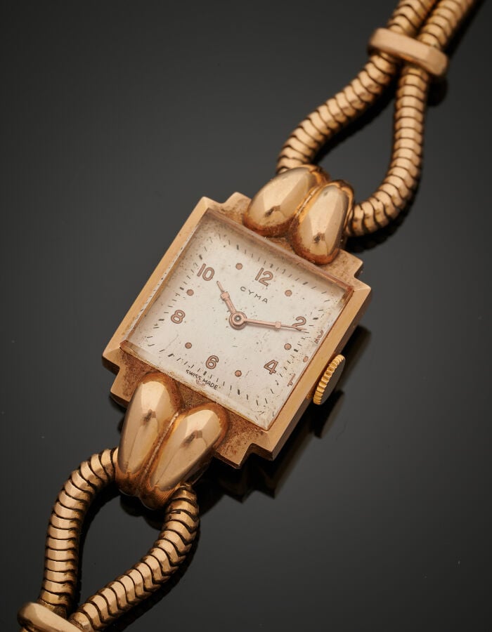 BRACELET MONTRE carrée de dame en or jaune (750‰). Attaches godronnées et brace…