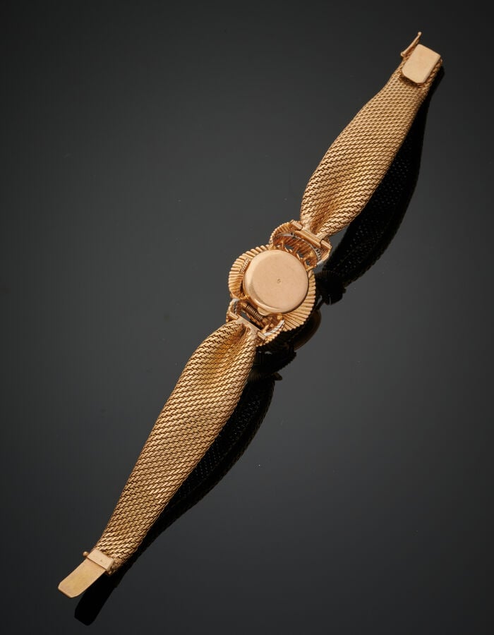 BRACELET MONTRE "noeud et volutes" ronde de dame en or jaune (750‰). La montre…