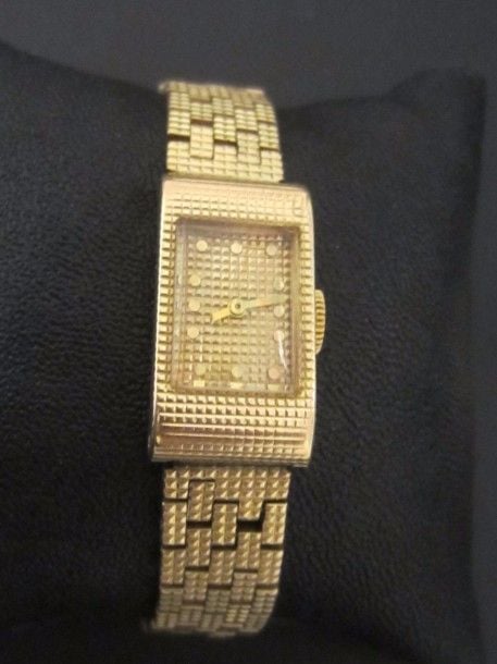 BRACELET MONTRE rectangulaire en or jaune (750 millièmes) entièrement ciselé à motifs de « pointe de diamants