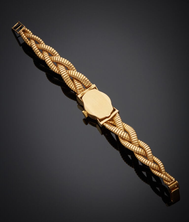 BRACELET MONTRE ronde de dame en or jaune, attaches "noeuds". Bracelet tressé à…
