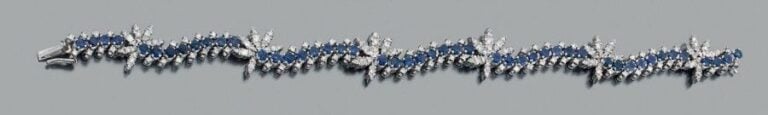 BRACELET ondulé en or gris (750 millièmes) ajouré serti d'alignements de saphirs ronds soulignés de diamants à motifs de palmette