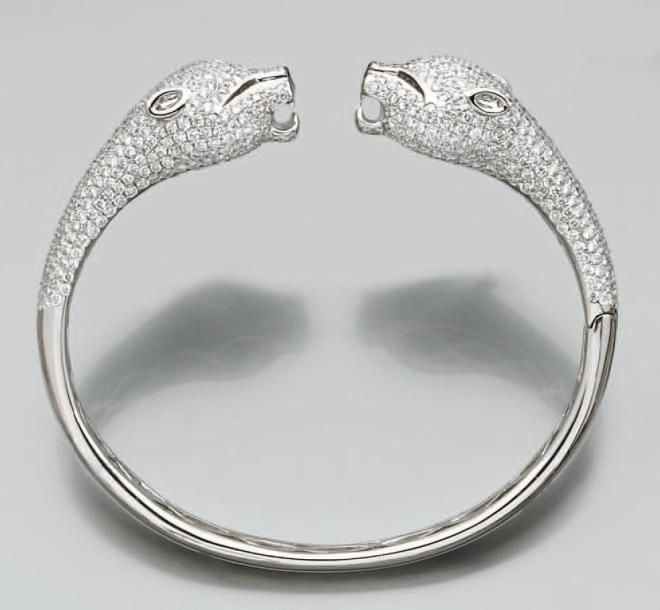 BRACELET «panthères» rigide ouvrant en or gris sculpté, ciselé et pavé de diamants taille brillan
