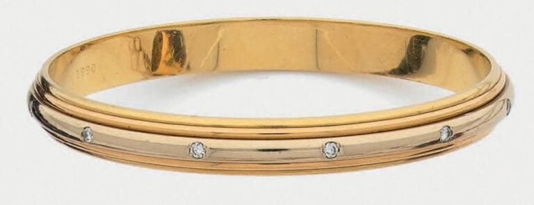 BRACELET rigide deux ors (750 millièmes) godronné parsemé de douze diamants taille brillan