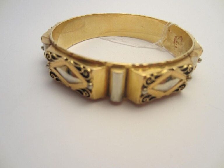 BRACELET rigide en or jaune et or gris (750 millièmes) à motifs crantés, losangiques et pont