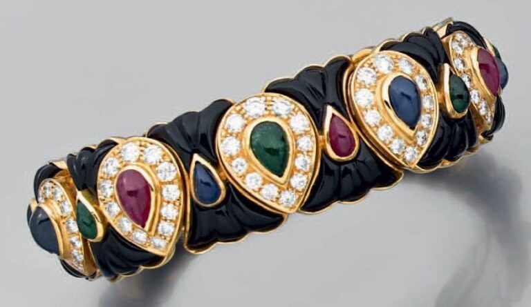 BRACELET rigide ouvert en or jaune et intérieur acier serti d'onyx, rubis, émeraudes et saphirs cabochons de forme poire et de diamants taille brillan