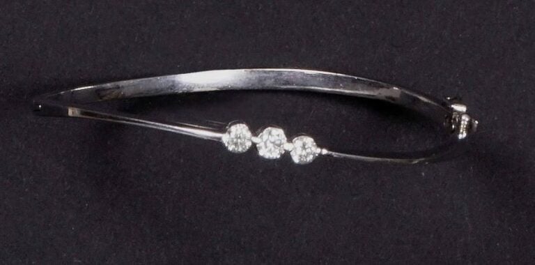 Bracelet rigide ouvrant en or blanc 9K (375%o) serti de trois diamants de taille brillant, en