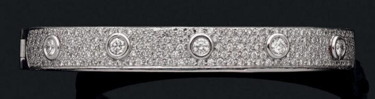 BRACELET rigide ouvrant en or gris (750 millièmes) entièrement serti d'un pavage de diamants et rehaussé de dix diamants taille brillant plus important