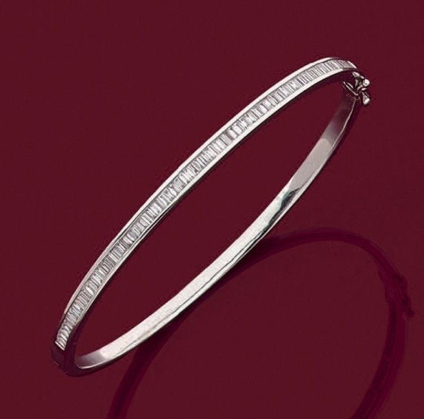 BRACELET rigide ouvrant en or gris (750 millièmes) partiellement serti d'un alignement de diamants baguette