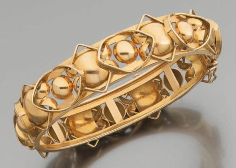 BRACELET rigide ouvrant en or jaune ajouré, boulé et découp