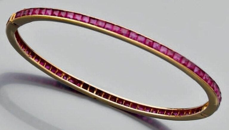 BRACELET rigide ouvrant en or jaune entièrement serti d'un alignement de rubis calibré