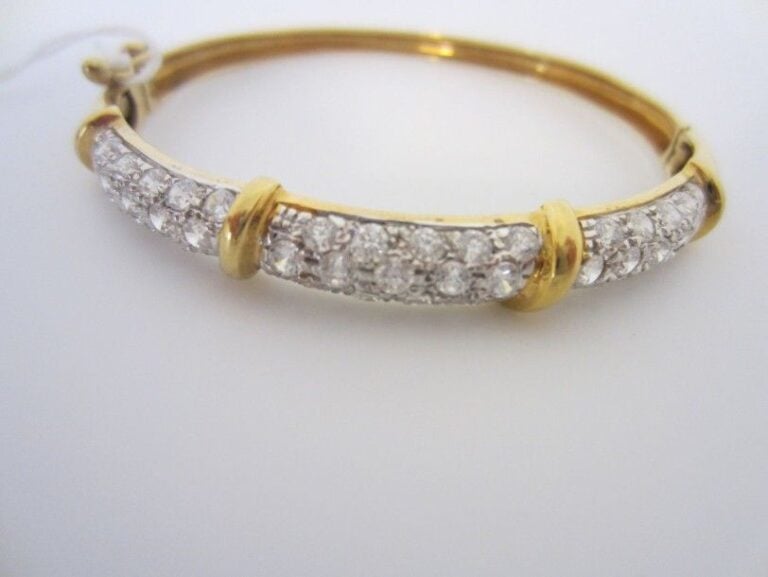 BRACELET rigide ouvrant en or jaune et or gris (750 millièmes) pavé de pierres blanche