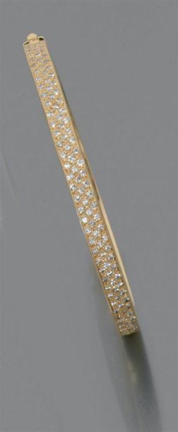 BRACELET rigide ouvrant en or jaune partiellement serti d'un pavage de diamants de taille brillan