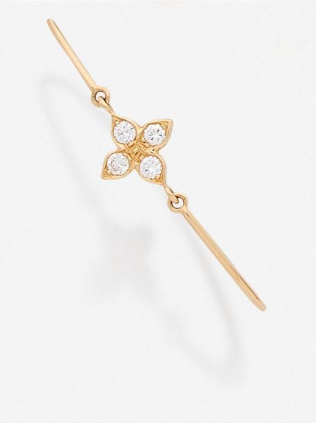 BRACELET semi-rigide en or jaune (750 millièmes) centré d'un «trèfle» serti de quatre diamants taille brillan