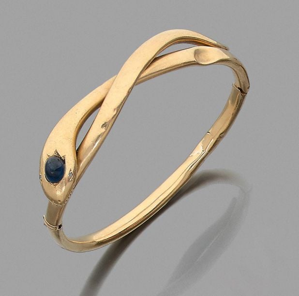 •BRACELET «serpent» en or jaune (750‰), serti d'un saphir cabochon, et deux diamants taillés en ros
