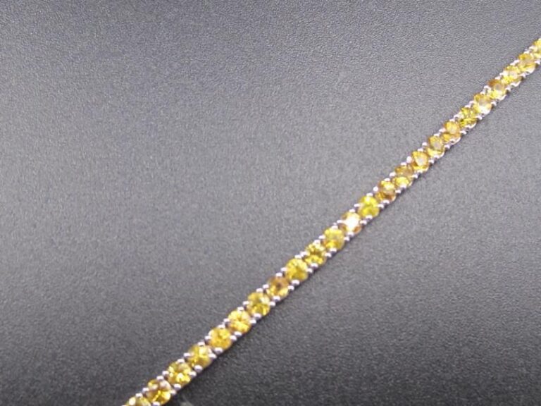 BRACELET souple en or gris (585 millièmes) 14 carats, serti d'un alignement de saphirs jaune