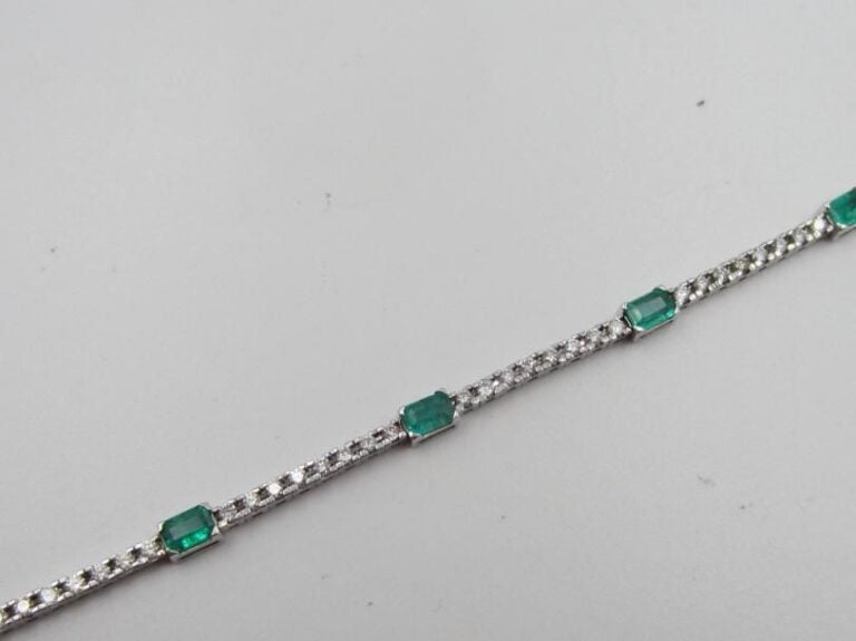 BRACELET souple en or gris (585 millièmes) 14 carats serti d’un alignement de diamants taille brillant alternés d’émeraudes rectangulaires taillées à degrés             Long        : 18 cm        Poids brut : 5,2 g