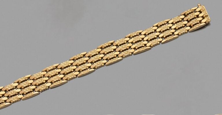 BRACELET souple en or jaune (750 millièmes) articulé et ciselé à motifs de fleurette