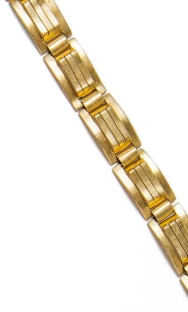 Bracelet " tank " articulé en or jaune 18K (750°/00) à maillons rectangulaires rainurés et ajouré
