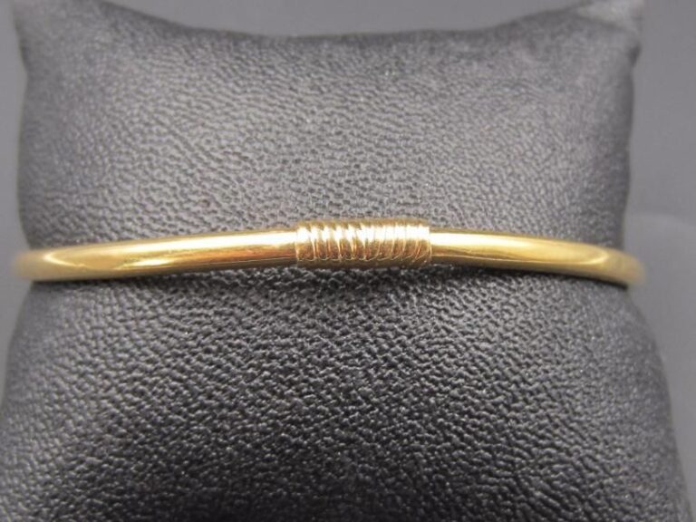 BRACELET tubulaire ouvrant flexible en or jaune  (750 millièmes), le fermoir godronn