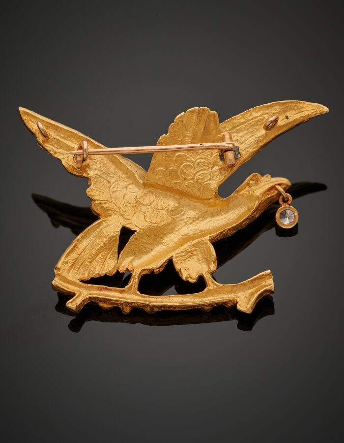 BROCHE "aigle sur sa branche" en or jaune (750‰) entièrement ciselé, le bec ret…