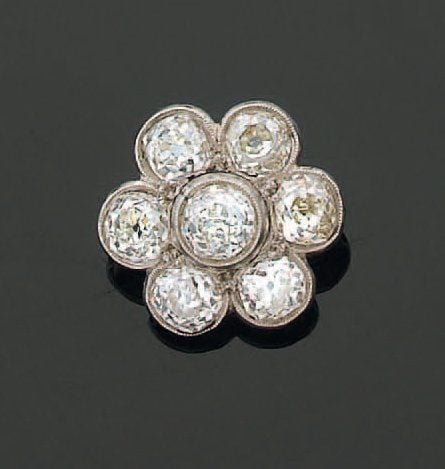 BROCHE (anciennement fermoir) « fleur » en platine et or gris sertis de sept diamants de taille ancienn