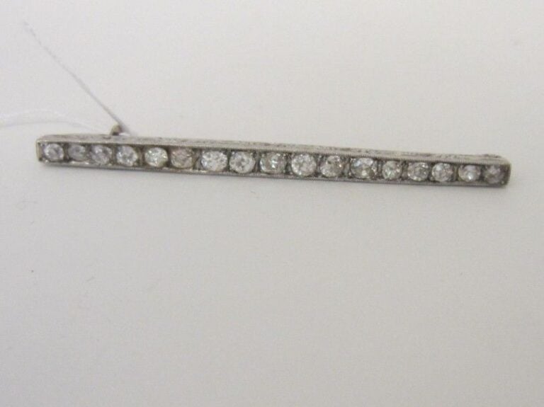 BROCHE barrette en or gris (750 millièmes) serti d'une ligne de diamants taille ancienne, en chut