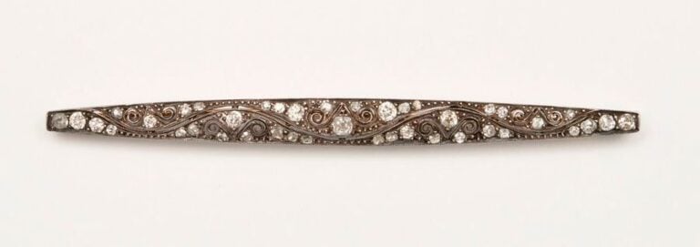 BROCHE barrette en or jaune 14 K et argent de forme ovale ajourée ornée d’une résille de quatre petits diamants, la plupart de taille ancienne et certains diamants taillés en rose