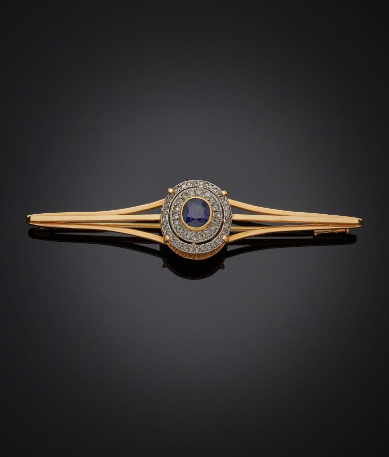 BROCHE " barrette" en or jaune et or gris (750‰) ajouré, serti d'un saphir de f…
