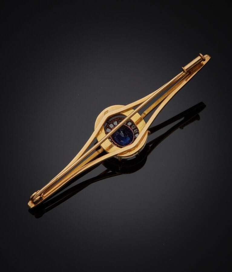 BROCHE " barrette" en or jaune et or gris (750‰) ajouré, serti d'un saphir de f…