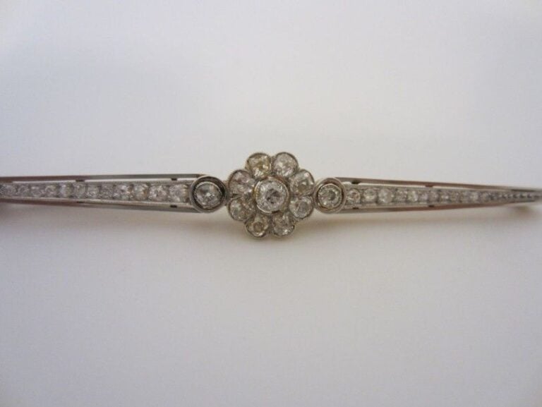 BROCHE BARRETTE en or jaune et or gris (750 millièmes) centré d?un motif fleur sertie et épaulée de diamant