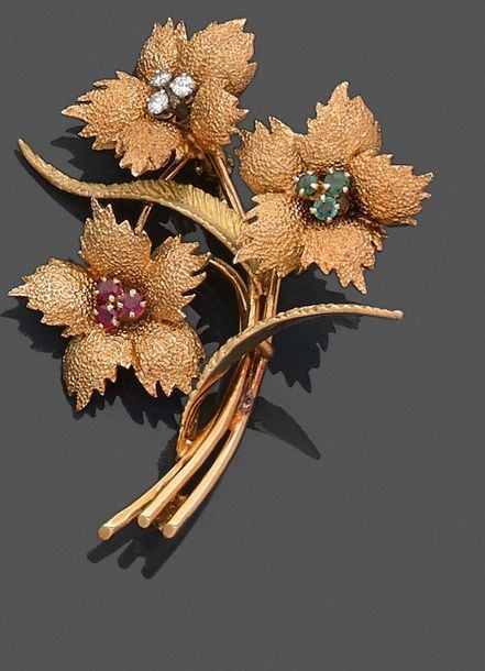 •BROCHE «bouquet de fleurs» en or jaune (750‰) amati et ciselé, serti de diamants, émeraudes et rubi