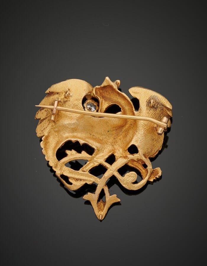 BROCHE "chimère" en or jaune (750‰) ajouré, entièrement ciselé, retenant un dia…
