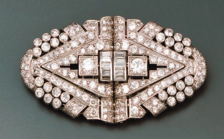Broche constituée de deux clips triangulaires en platine et or gris ajourés, sertie de diamants ronds et diamants baguette