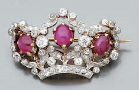 BROCHE «couronne» en platine et or jaune serti de trois rubis cabochons de forme ovale entourés de diamants de taille ancienn