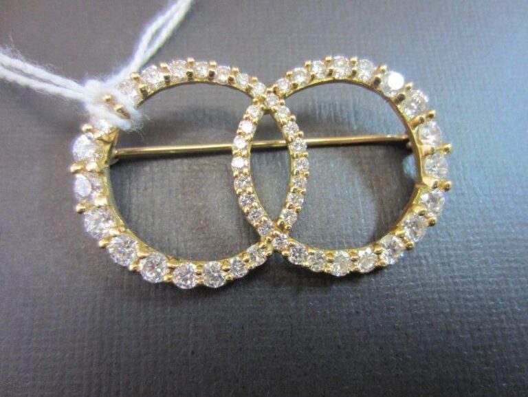BROCHE «deux anneaux» en or jaune (750 millièmes) ajouré serti de diamants taille brillan