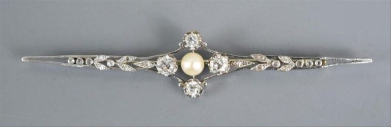 Broche en or centrée d'une perle entourée de quatre diamants taille ancienne épaulée de diamants taillés rose (poinçon tête d'aigle