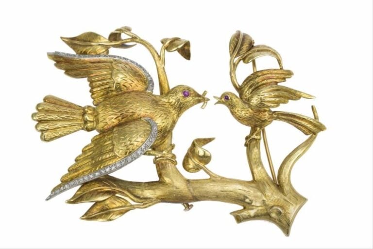 Broche en or jaune 18K (750°/00) figurant un oiseau branché donnant un vers de terre à son oisillo