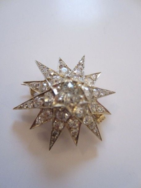 BROCHE «étoile» en or jaune 14 carats (585 millièmes) et argent serti de diamants taille ancienne dont un au centre plus importan