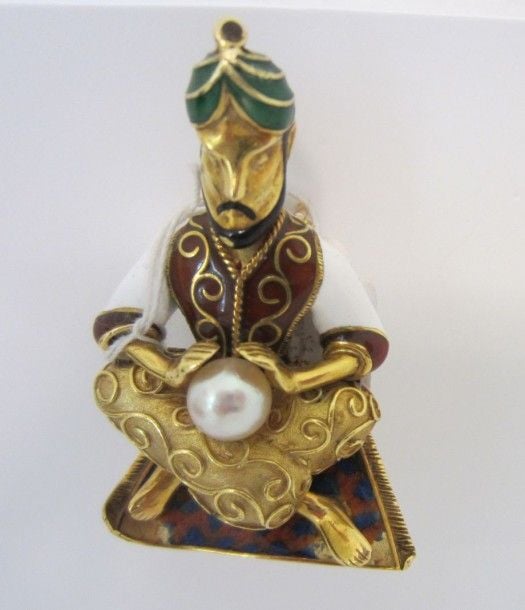 BROCHE "fakir sur son tapis volant" en or jaune (750 millièmes) et émail translucide polychrome ornée d'une perle figurant une boule de crista