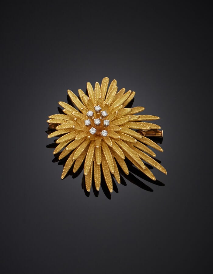 BROCHE "fleur" en or jaune (750‰) mat, entièrement ciselé, serti de huit diaman…