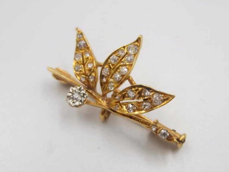 Broche « fleur et feuillage » en or jaune (750 ‰) serti de petits diamant
