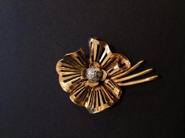 BROCHE «fleur stylisée» en or jaune (750 millièmes) ajouré serti de petit diamant