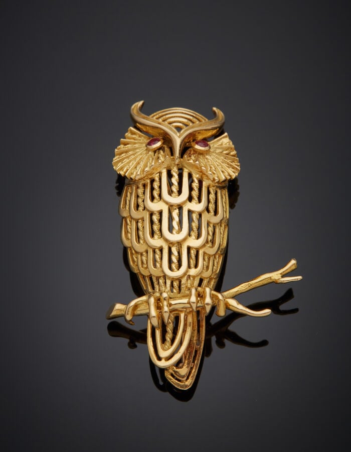 BROCHE "hibou sur sa branche" en or jaune (750‰) ajouré, ciselé, les yeux serti…