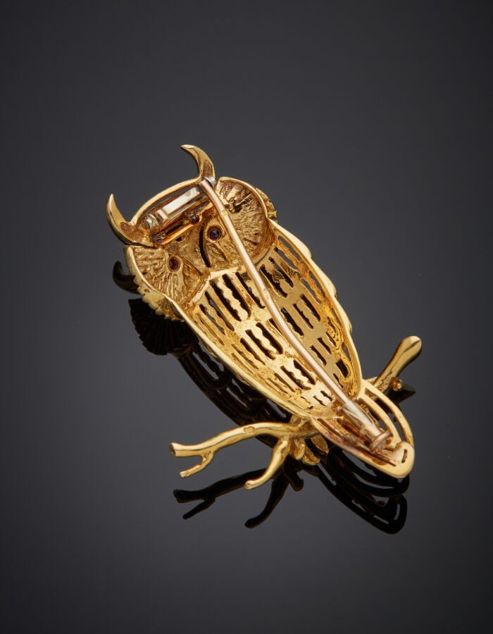 BROCHE "hibou sur sa branche" en or jaune (750‰) ajouré, ciselé, les yeux serti…