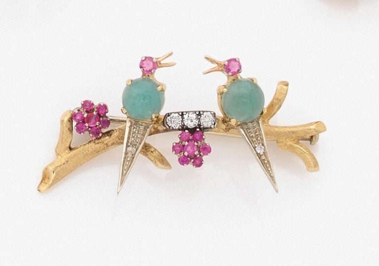 •BROCHE «inséparables sur leur branche» en or jaune (750‰) et argent (925‰) serti de diamants, émeraudes cabochons, et rubi